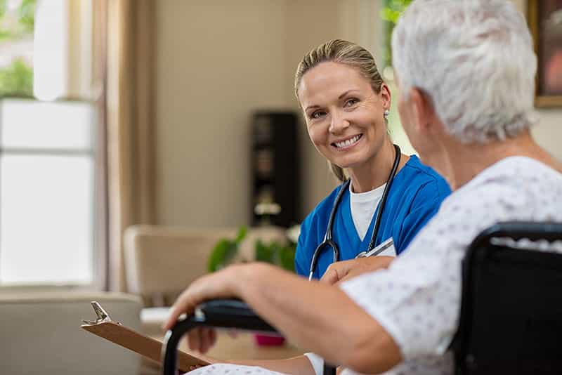 Nurse in conversation with elderly person.
